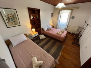 a small bedroom with two beds and a window at La Dimora di Basilica in Ágios Matthaíos