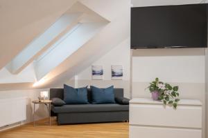 a living room with a couch and a flat screen tv at Paky Appartements 00317 in Bruck an der Leitha +2 photos
