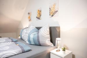 a bedroom with a bed with blue and white pillows at Paky Appartements 00317 in Bruck an der Leitha