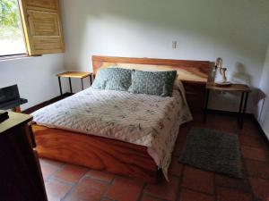 a bedroom with a wooden bed with two pillows at La Casona Del Retiro in Medellín +14 photos