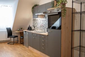 a kitchen with gray cabinets and a stove at Paky Appartements 00317 in Bruck an der Leitha