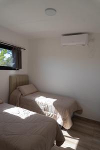 a bedroom with two beds and a window at Aires de Laguna in Chascomús