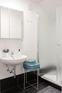 a white bathroom with a sink and a shower at Paky Appartements 00317 in Bruck an der Leitha