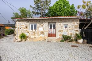 a stone house with a door on a brick driveway at Mourisco Guest House in Alijó