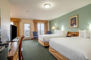 a hotel room with two beds and a flat screen tv at Wonder View Inn - Bar Harbor Collection in Bar Harbor