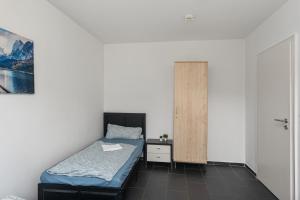a small bedroom with a bed and a cabinet at MK Apartment Delmenhorst nähe Bremen 21 in Delmenhorst +2 photos