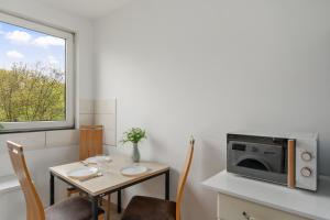 a small dining room with a table and a microwave at MK Apartment Delmenhorst nähe Bremen 21 in Delmenhorst