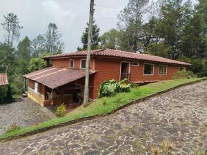 a house on a hill next to a road at La Casona Del Retiro in Medellín
