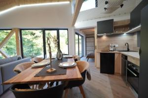 a kitchen and dining room with a wooden table in a house at Chalets Szőcs-birtok in Izvoare