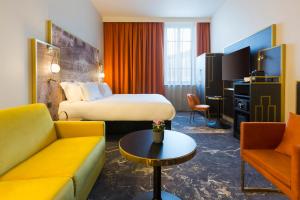 a hotel room with a bed and a couch at Le Grand Hôtel Dieu by SOWELL COLLECTION in Nîmes
