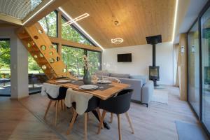 a dining room and living room with a table and chairs at Chalets Szőcs-birtok in Izvoare