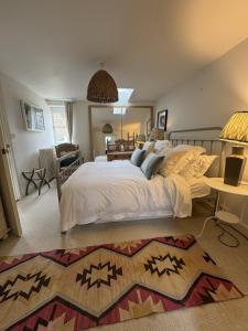 a bedroom with a large bed and a living room at The Old Barn in Farthinghoe