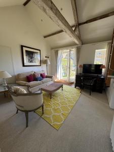 a living room with a couch and a television at The Old Barn in Farthinghoe