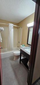 a bathroom with a toilet and a sink and a mirror at Gardner Inn in Gardner +18 photos