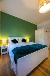 a bedroom with a large bed with a green wall at Bed & Breakfast Across The Room(e) in Rome +24 photos