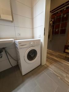a laundry room with a washing machine and a sink at Smartstay Porta in Porta Westfalica +13 photos