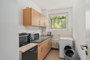 a kitchen with a sink and a washing machine at MK Apartments Delmenhorst nähe Bremen 20 in Delmenhorst