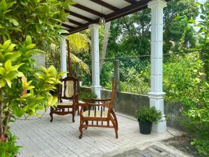 two chairs and a table on a porch at Hamilton Breeze villa in Pamunugama