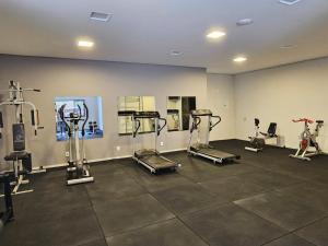 a gym with several tread machines in a room at Hotel Aquarius do Vale in São José dos Campos
