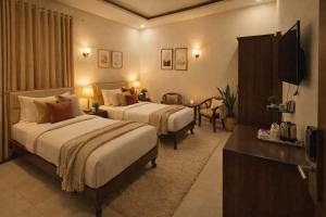 a hotel room with two beds and a television at Goyal Hotelirs - Hotel The Agra Grande, Agra in Agra