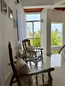 a living room with two chairs and a table at Hamilton Breeze villa in Pamunugama