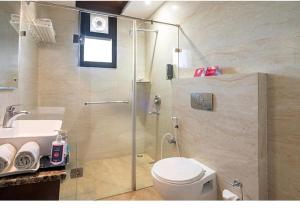 a bathroom with a shower and a toilet and a sink at Goyal Hotelirs - Hotel The Agra Grande, Agra in Agra +22 photos