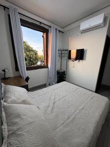 a bedroom with a large white bed and a window at Pousada Carro de Boi in Lavras +102 photos