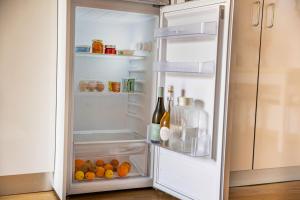 an open refrigerator with bottles of wine and oranges at Viosinho guest house in Alijó