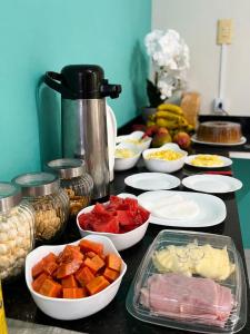 a table topped with bowls of different types of food at Hotel Natureza in Anhanduí