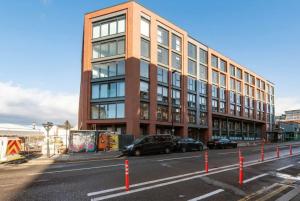 a large brick building with cars parked in front of it at Central Birmingham 2 BED Modern Spacious Apartment in Birmingham