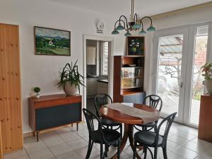 a kitchen and dining room with a table and chairs at Sára Vendégház in Szentes