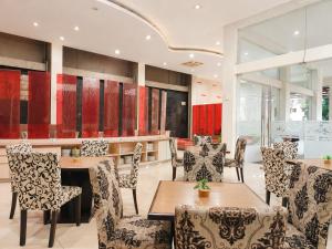 a restaurant with tables and chairs and red cabinets at Scarlet Hotel Stasiun Bandung in Bandung