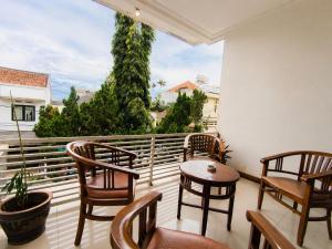 a balcony with chairs and tables and a large window at Scarlet Hotel Stasiun Bandung in Bandung