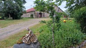 a statue of a woman sitting on a rock in front of a house at gite art et nature in Thorigny +2 photos