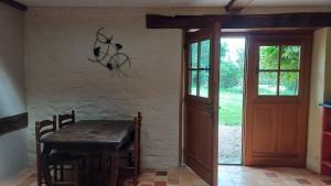 a dining room with a wooden table and a door at gite art et nature in Thorigny