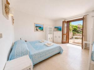 a bedroom with a bed and a large window at Baja Sardinia CB 1 with Pool 100m from the Beach in Baja Sardinia
