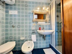 a blue tiled bathroom with a toilet and a sink at Baja Sardinia CB 1 with Pool 100m from the Beach in Baja Sardinia +8 photos