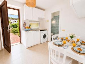 a kitchen and dining room with a table with food at Baja Sardinia CB 1 with Pool 100m from the Beach in Baja Sardinia