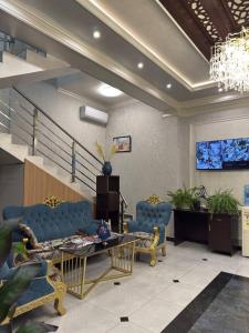 a living room with blue furniture and a chandelier at Almaz Hotel Uzbekistan in Tashkent