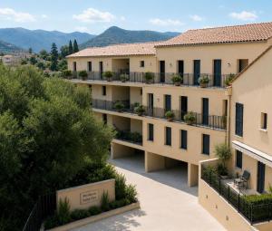 an apartment building with balconies with mountains in the background at Résidence Saint Flor in Saint-Florent