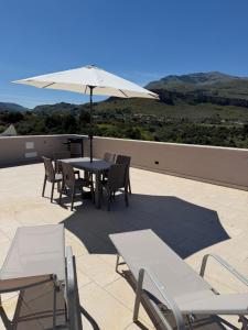 a table and chairs with an umbrella on a patio at Luxekey ETTORE HOUSE in Scopello