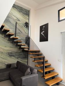 a staircase in a living room with a couch at Luxekey ETTORE HOUSE in Scopello