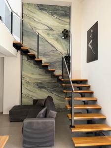 a staircase in a living room with a couch at Luxekey ETTORE HOUSE in Scopello +49 photos