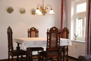 a dining room with a table and chairs and a chandelier at Die gute Stube in Wernigerode