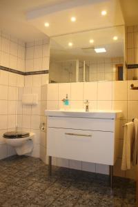 a bathroom with a white sink and a toilet at Die gute Stube in Wernigerode