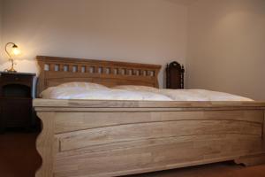 een groot houten bed in een kamer met een lamp bij Die gute Stube in Wernigerode