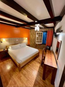 a bedroom with a large bed and a table at Hotel Vegas in Santiago