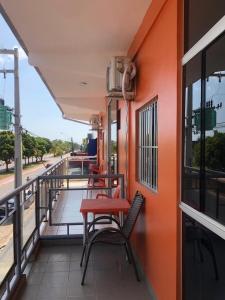 two chairs and a red table on a balcony at Raludi Hotel in Barcarena