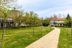 a walkway in a park with trees and houses at Zamárdi Parti Apartman in Zamárdi