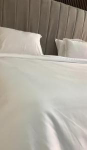 a white bed with white sheets and pillows at Kris Courts in Ibadan